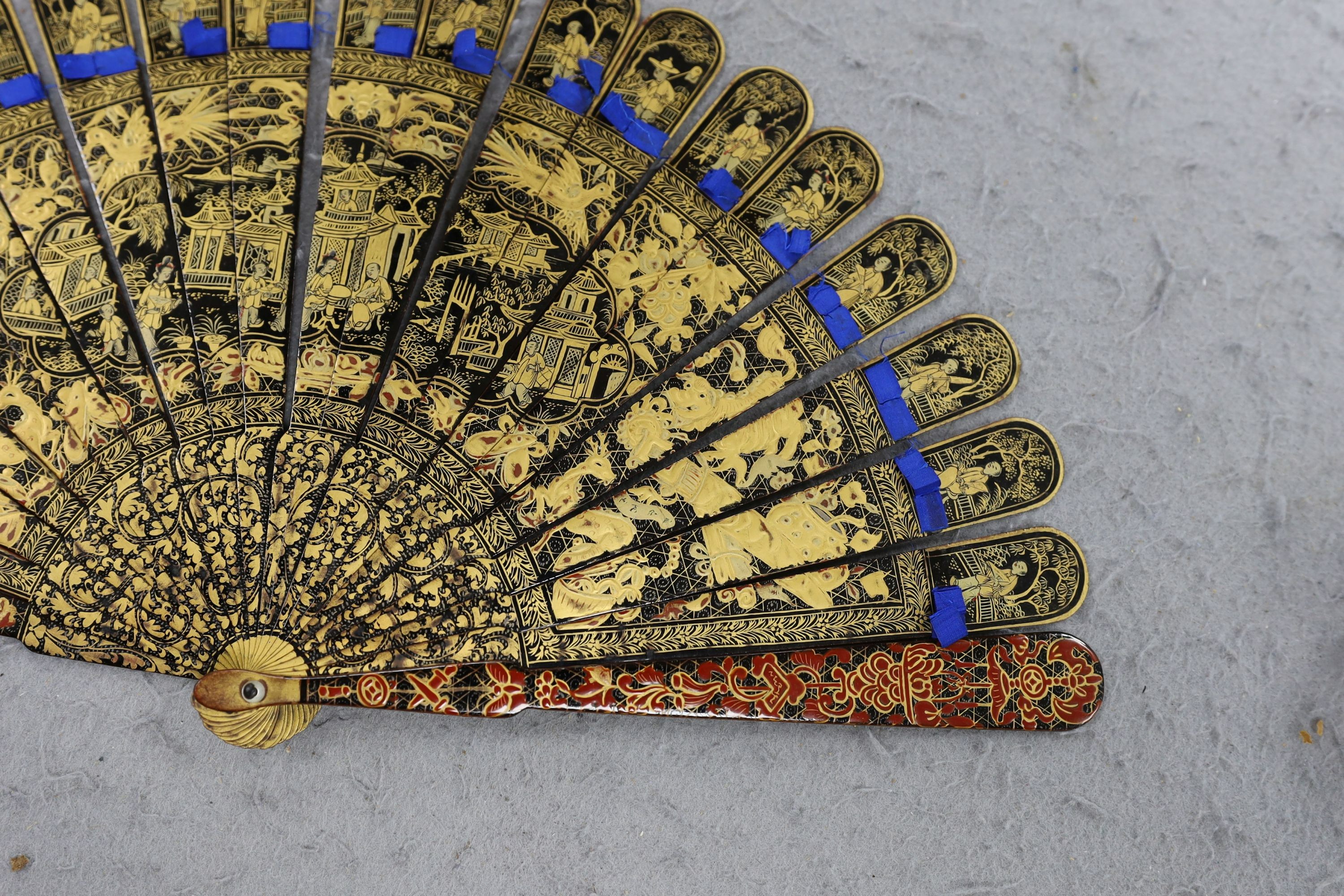A Chinese gilt-decorated lacquer fan in a brocade covered case, 19th century